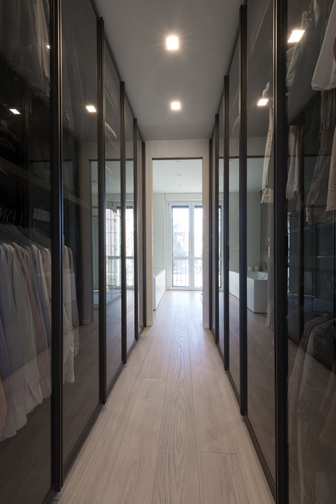 Exempel på ett litet modernt walk-in-closet för könsneutrala, med luckor med glaspanel, bruna skåp, ljust trägolv och beiget golv