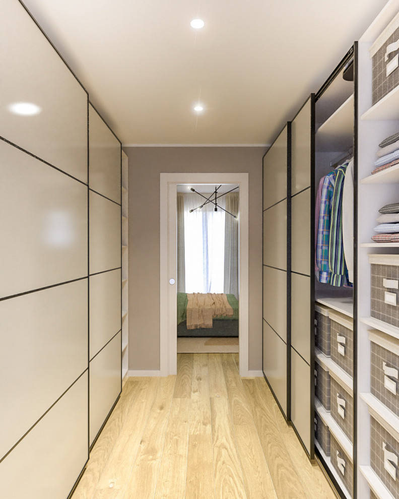 Diseño de armario vestidor unisex nórdico de tamaño medio con armarios con paneles lisos, puertas de armario beige, suelo de madera clara y bandeja