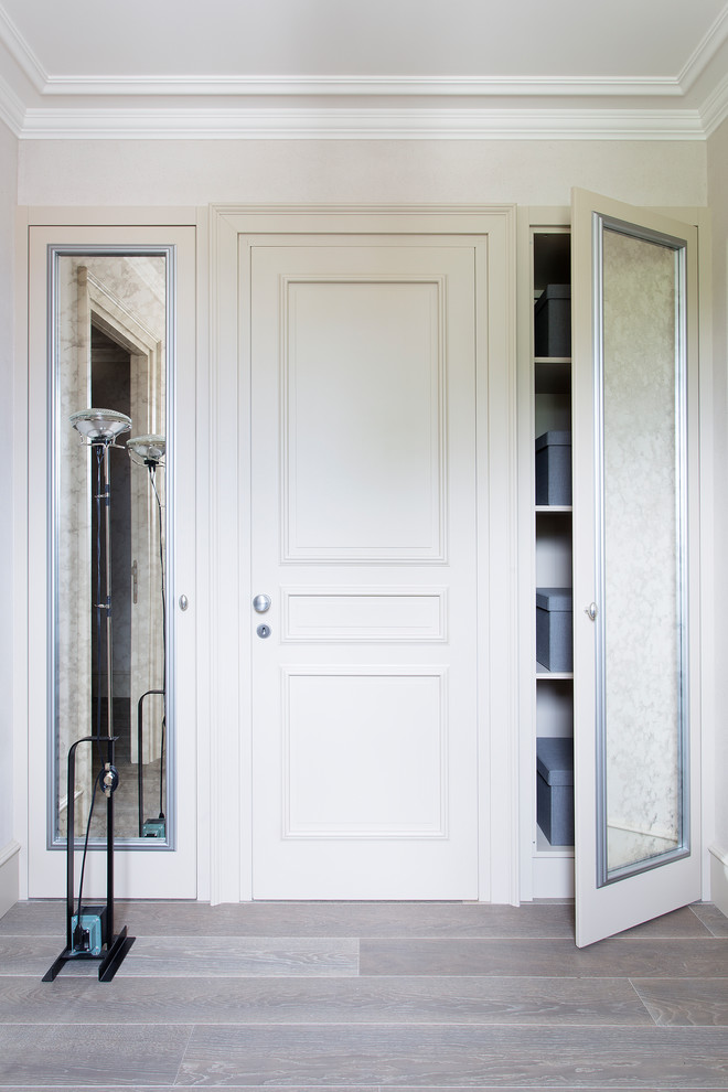 Diseño de armario unisex clásico extra grande con armarios con paneles empotrados, puertas de armario blancas y suelo de madera oscura