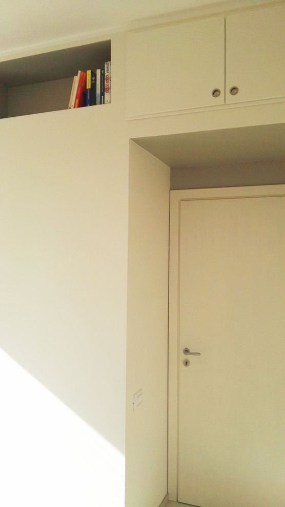 Esempio di un armadio o armadio a muro unisex moderno di medie dimensioni con ante a filo, ante in legno chiaro, parquet chiaro e pavimento beige
