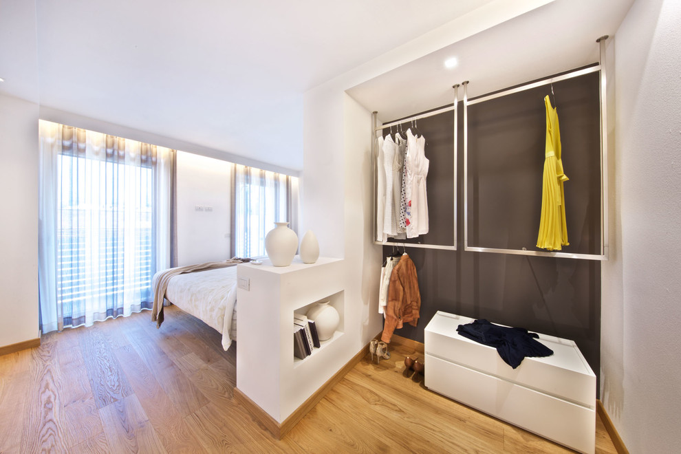 Photo of a small contemporary gender neutral wardrobe in Venice with open cabinets and medium hardwood flooring.