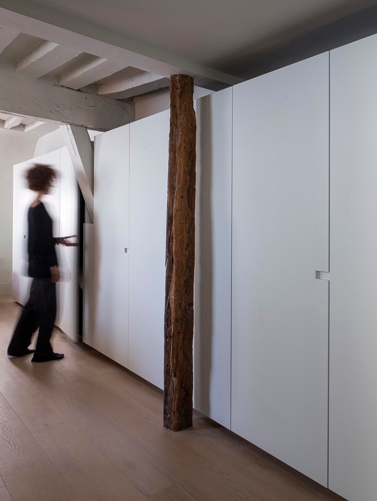 Diseño de armario unisex contemporáneo grande con armarios con paneles lisos, puertas de armario blancas y suelo de madera en tonos medios