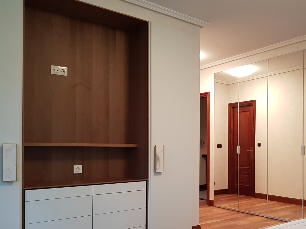 Idée de décoration pour une armoire encastrée design de taille moyenne et neutre avec un sol en bois brun.