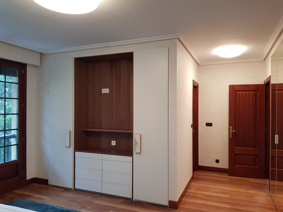 Exemple d'une armoire encastrée tendance de taille moyenne et neutre avec un sol en bois brun.