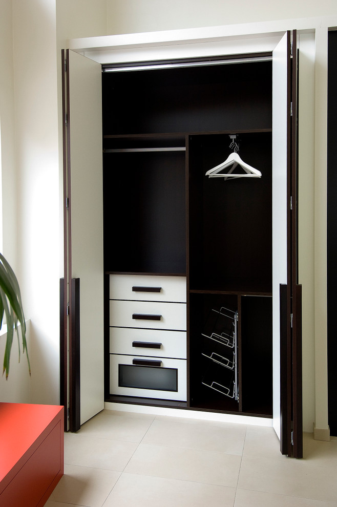 Ejemplo de armario unisex actual pequeño con armarios con paneles lisos, puertas de armario blancas y suelo de baldosas de cerámica