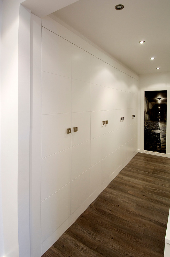 Esempio di un armadio o armadio a muro unisex classico di medie dimensioni con ante lisce, ante bianche e pavimento in legno massello medio
