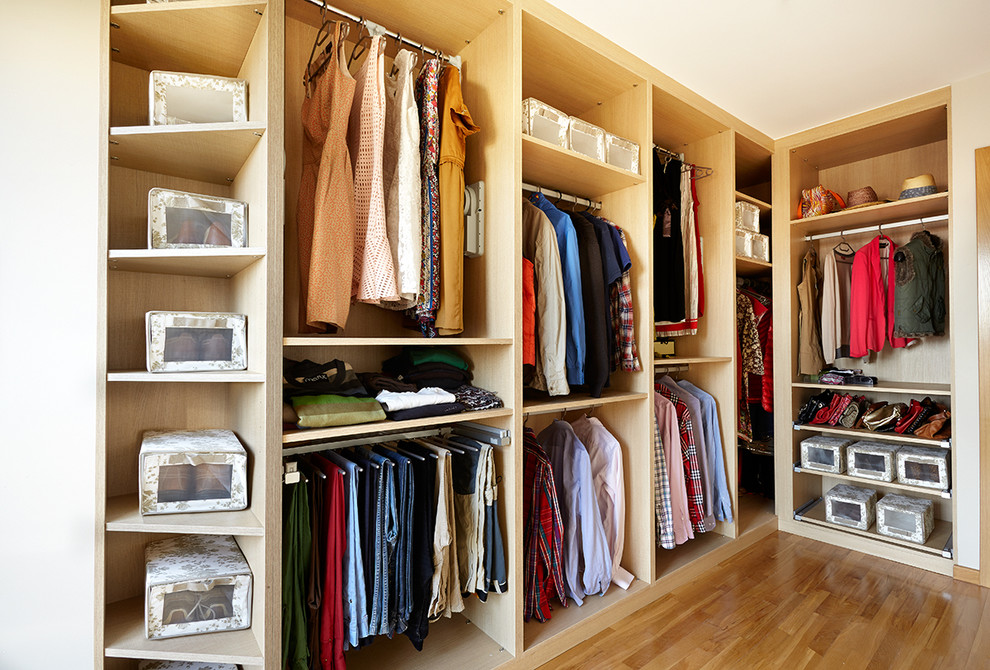 Modelo de armario vestidor unisex clásico renovado de tamaño medio con armarios abiertos, suelo de madera en tonos medios y puertas de armario de madera clara