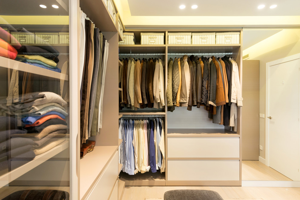 Ejemplo de armario vestidor unisex clásico renovado grande con suelo de madera clara
