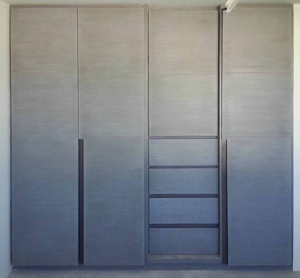 Cette photo montre un dressing moderne de taille moyenne pour un homme avec un placard avec porte à panneau encastré, des portes de placard grises et un sol en carrelage de céramique.