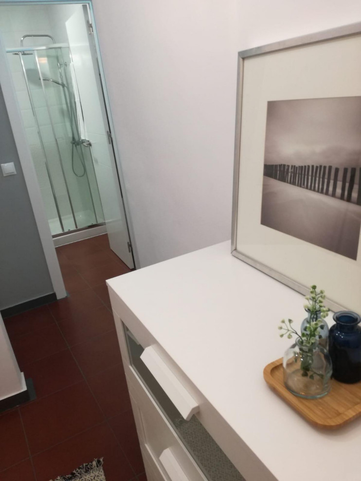 マドリードにある小さなおしゃれなフィッティングルーム (レイズドパネル扉のキャビネット、白いキャビネット、赤い床) の写真