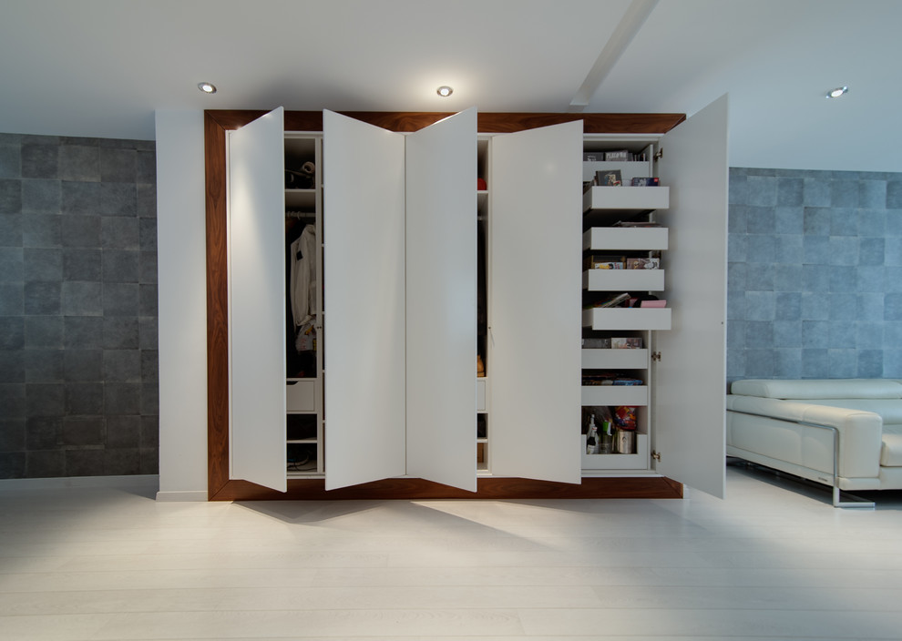 Photo of a medium sized traditional gender neutral standard wardrobe in Other with flat-panel cabinets, white cabinets and painted wood flooring.