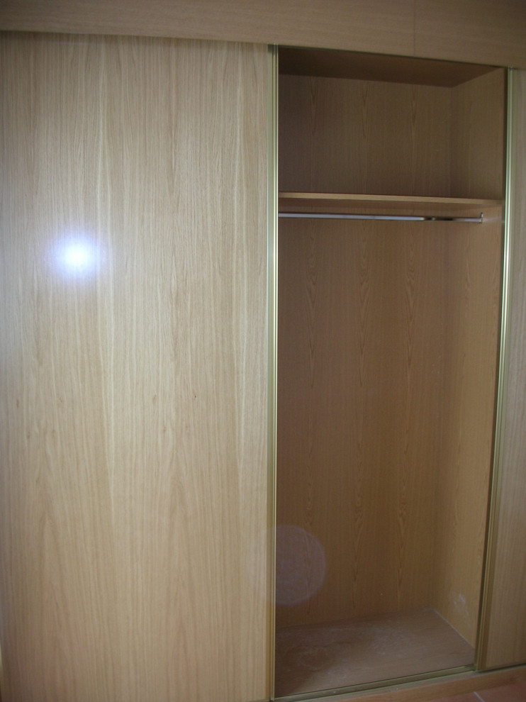 Foto de armario y vestidor unisex minimalista de tamaño medio con a medida, armarios con paneles lisos, puertas de armario de madera oscura, suelo de madera en tonos medios y suelo marrón