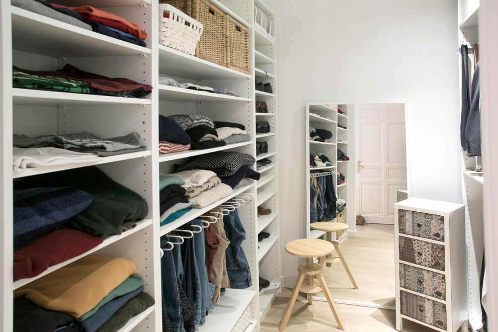 Design ideas for a large traditional gender neutral walk-in wardrobe in Madrid with open cabinets, white cabinets and light hardwood flooring.