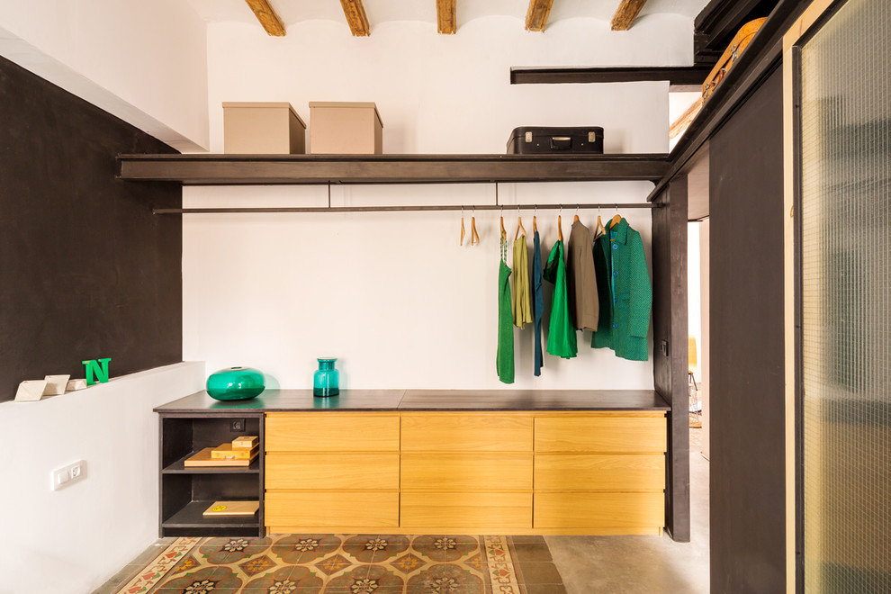 Идея дизайна: гардеробная комната среднего размера, унисекс в современном стиле с открытыми фасадами, фасадами цвета дерева среднего тона, бетонным полом и разноцветным полом