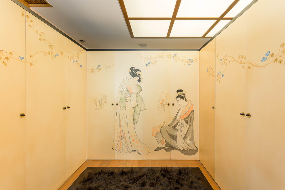 Cette photo montre un dressing asiatique de taille moyenne avec un placard à porte plane, parquet clair et un sol beige.