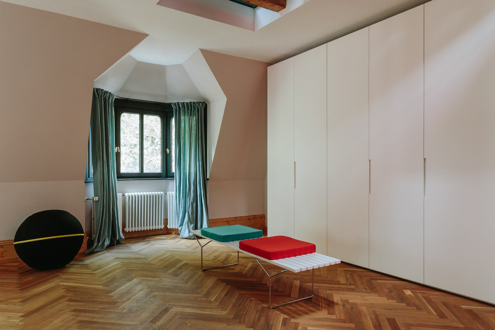 Idéer för ett stort minimalistiskt omklädningsrum för könsneutrala, med släta luckor, vita skåp, mellanmörkt trägolv och brunt golv