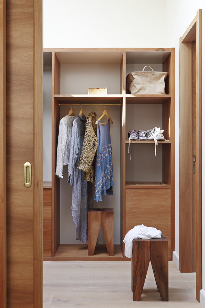 This is an example of a medium sized classic gender neutral walk-in wardrobe in Madrid with open cabinets, medium wood cabinets and light hardwood flooring.