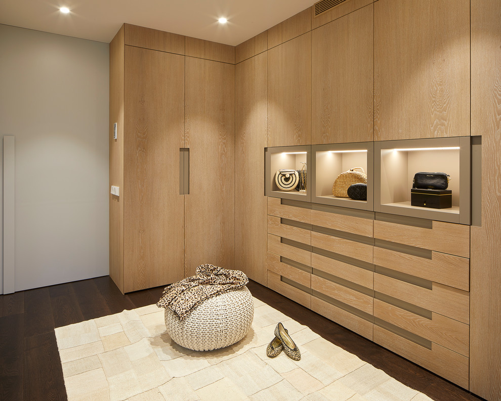 Стильный дизайн: гардеробная комната в современном стиле с плоскими фасадами, светлыми деревянными фасадами, темным паркетным полом и бежевым полом для женщин - последний тренд