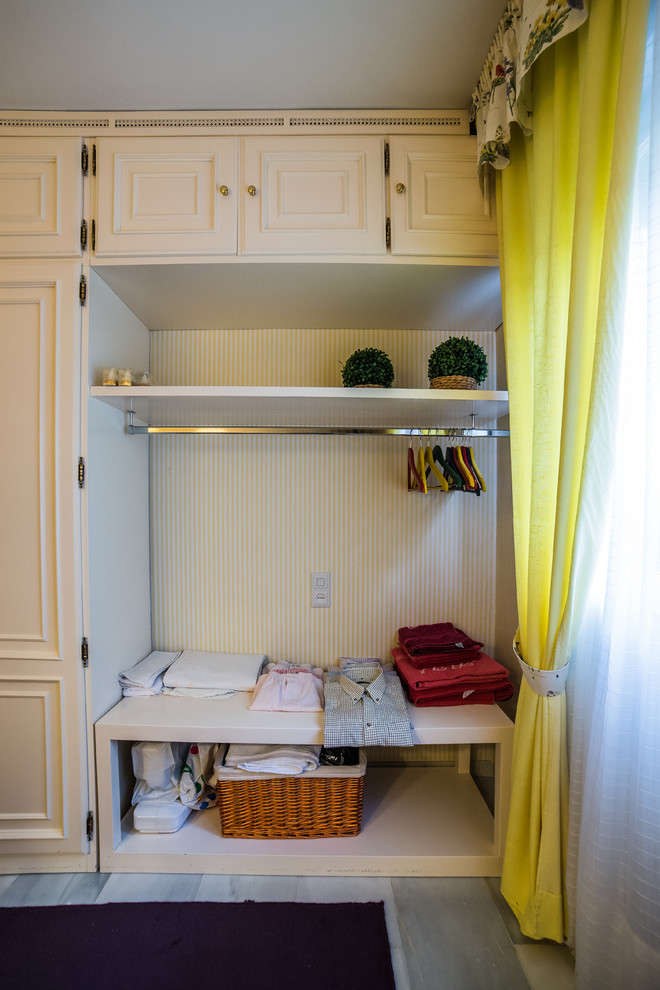 Foto di un piccolo armadio o armadio a muro unisex classico con ante con bugna sagomata e ante bianche