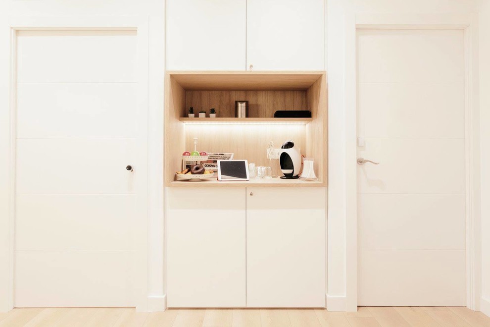 Modelo de armario vestidor unisex escandinavo pequeño con armarios con paneles lisos, puertas de armario blancas y suelo de madera clara