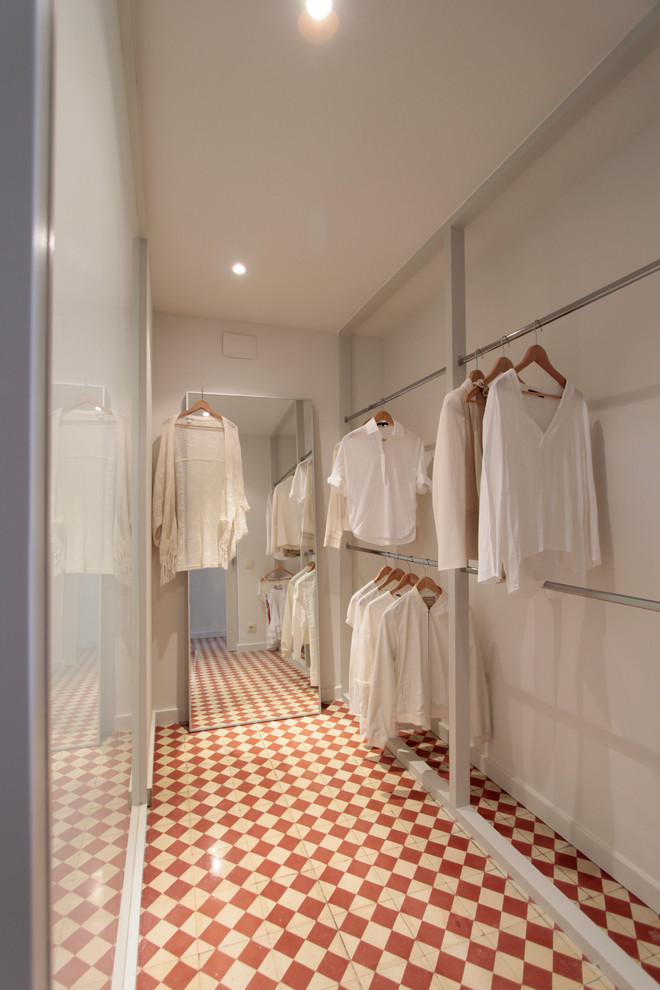 Идея дизайна: большая гардеробная комната унисекс в скандинавском стиле с открытыми фасадами, полом из керамической плитки и разноцветным полом