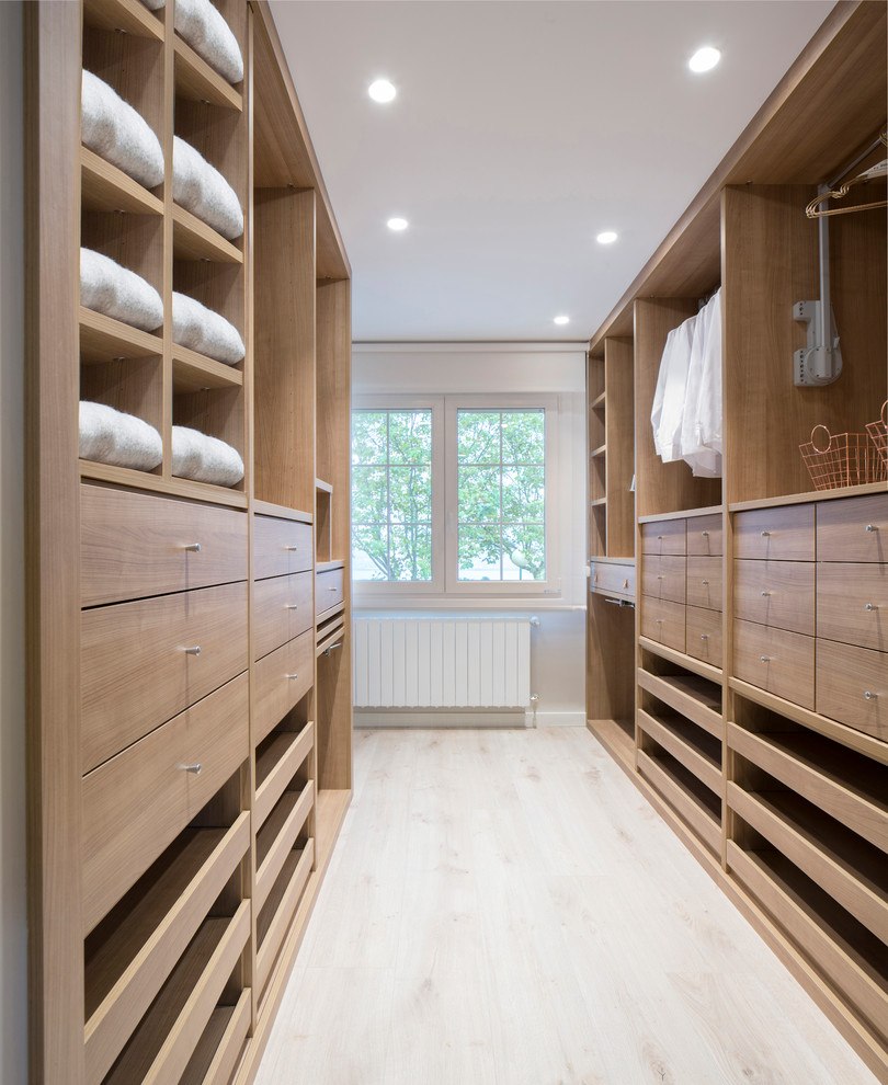 Diseño de vestidor unisex contemporáneo grande con armarios abiertos, puertas de armario de madera oscura, suelo de madera clara y suelo beige