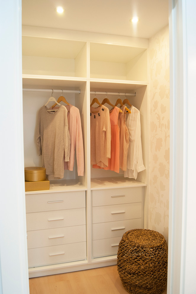 Cette photo montre un dressing scandinave de taille moyenne et neutre avec un placard sans porte, des portes de placard blanches et un sol en bois brun.