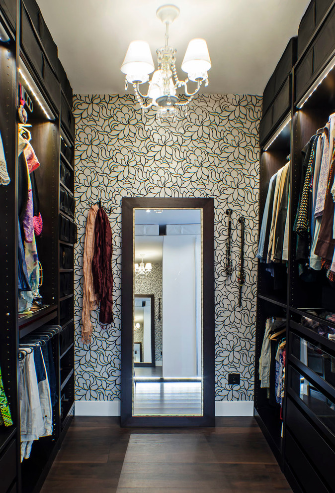 Exemple d'un dressing room chic de taille moyenne pour une femme avec un placard sans porte, des portes de placard noires, parquet foncé et un sol marron.