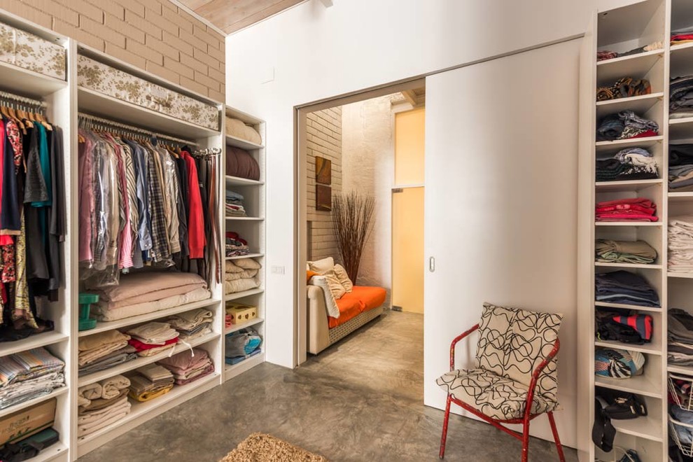 Idéer för att renovera ett stort funkis walk-in-closet för könsneutrala, med öppna hyllor, vita skåp, betonggolv och grått golv