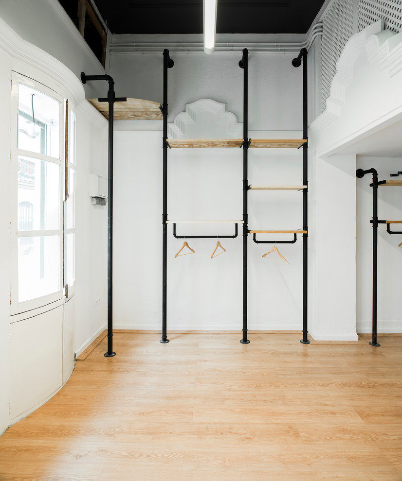 Immagine di uno spazio per vestirsi unisex minimalista di medie dimensioni con nessun'anta e pavimento in legno massello medio