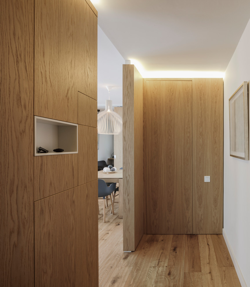 Ejemplo de armario vestidor minimalista con puertas de armario de madera oscura y suelo de madera en tonos medios