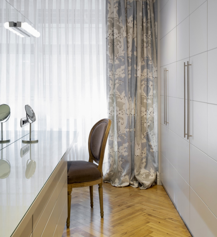 Foto di uno spazio per vestirsi per donna design di medie dimensioni con ante lisce, ante bianche e pavimento beige