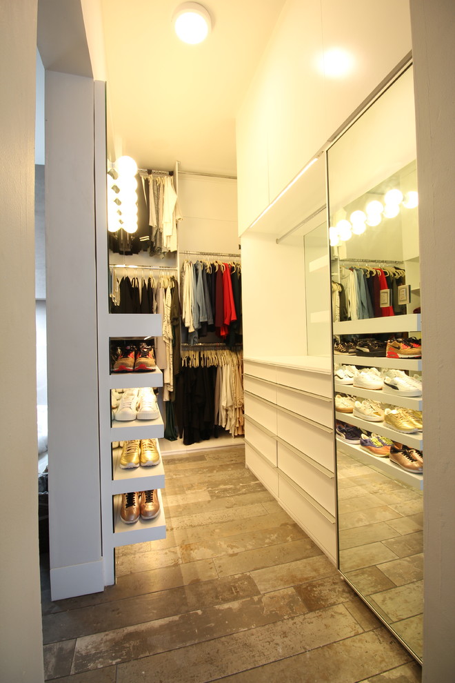 Diseño de armario vestidor de mujer minimalista grande con armarios con paneles lisos, puertas de armario blancas, suelo de baldosas de porcelana y suelo gris