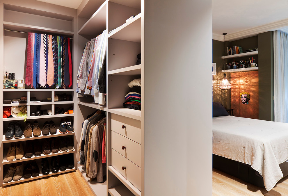 Ejemplo de armario vestidor unisex contemporáneo de tamaño medio con armarios abiertos, puertas de armario blancas y suelo de madera en tonos medios