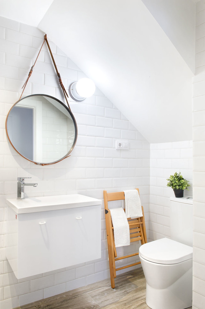 Идея дизайна: туалет среднего размера в скандинавском стиле с плоскими фасадами, белыми фасадами, раздельным унитазом, белыми стенами, паркетным полом среднего тона и монолитной раковиной