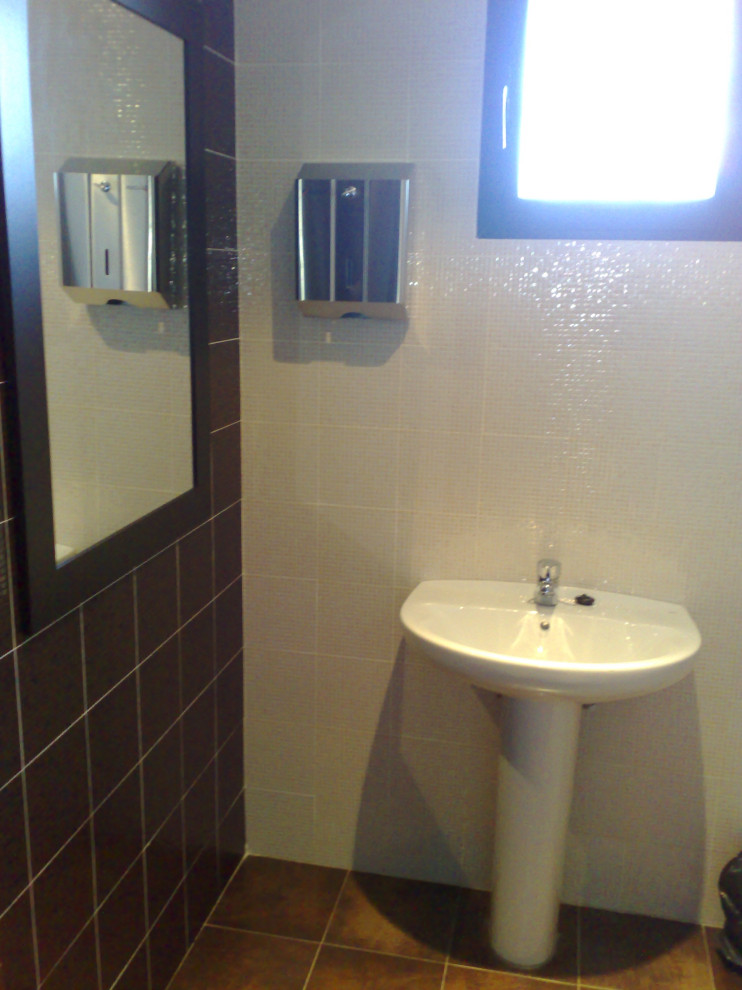 Inspiration för ett mellanstort funkis toalett, med vita skåp, en toalettstol med separat cisternkåpa, flerfärgad kakel, keramikplattor, flerfärgade väggar, ett piedestal handfat och brunt golv