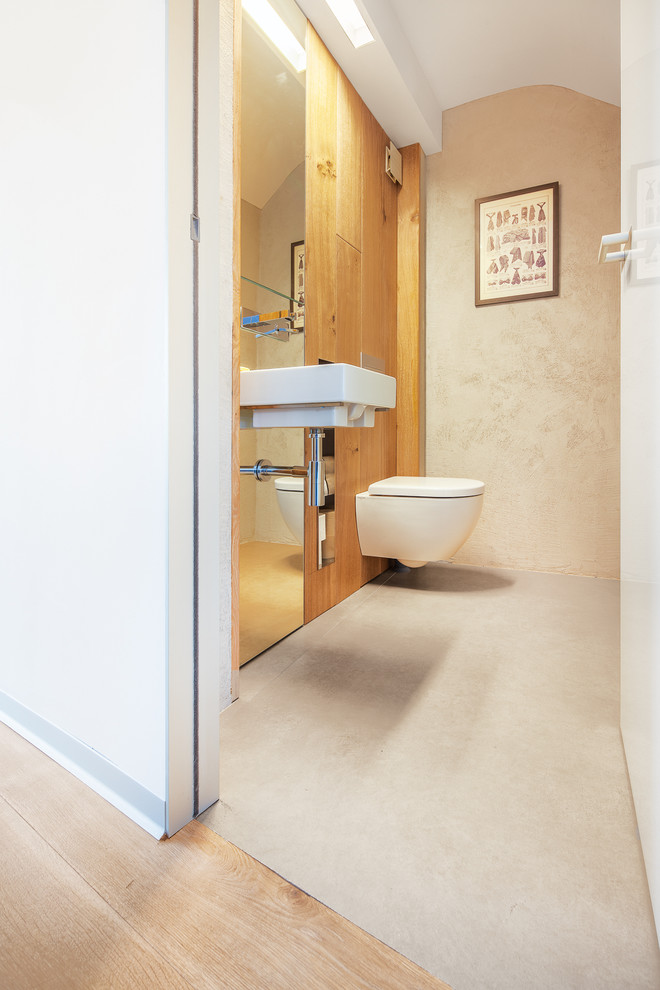 Idée de décoration pour un WC suspendu design de taille moyenne avec un mur beige et un lavabo suspendu.
