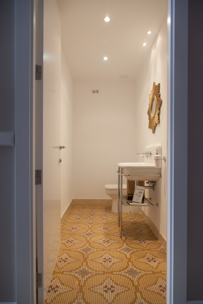 This is an example of a small contemporary cloakroom in Valencia with open cabinets, white walls, ceramic flooring and a console sink.