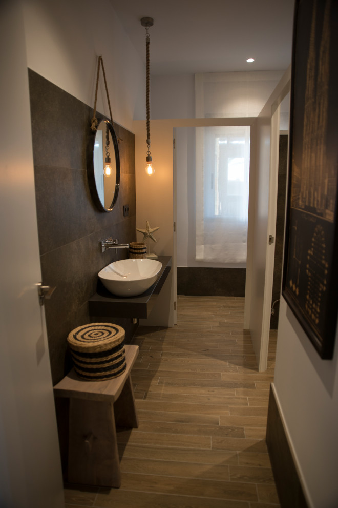 Стильный дизайн: туалет в современном стиле с белыми фасадами, коричневой плиткой, коричневыми стенами, полом из плитки под дерево, столешницей из дерева и подвесной тумбой - последний тренд