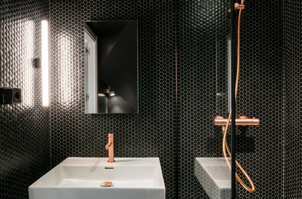 На фото: туалет в современном стиле с плиткой мозаикой, черными стенами и бетонным полом с