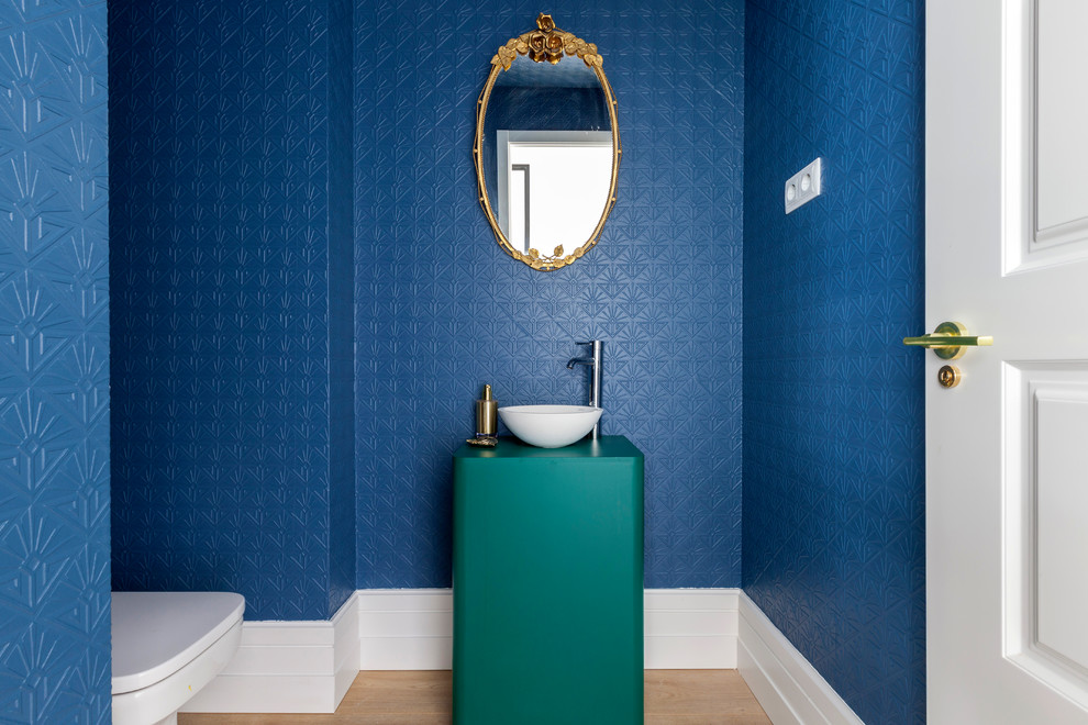Diseño de aseo contemporáneo con paredes azules, suelo de madera en tonos medios, lavabo sobreencimera y suelo marrón