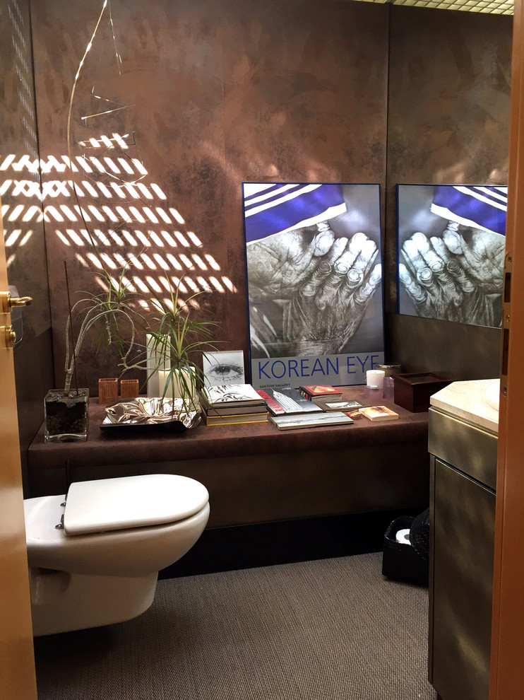 Imagen de aseo bohemio pequeño con armarios con paneles lisos, sanitario de pared, paredes marrones y lavabo encastrado