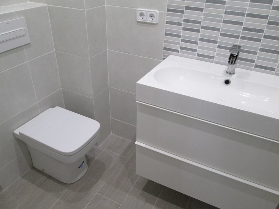 Kleine Moderne Gästetoilette mit flächenbündigen Schrankfronten, weißen Schränken, Toilette mit Aufsatzspülkasten, grauer Wandfarbe, Keramikboden und integriertem Waschbecken in Barcelona