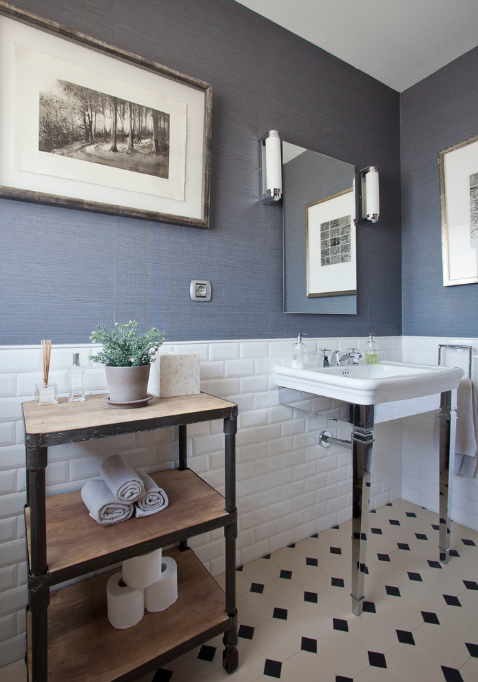 Inredning av ett klassiskt litet toalett, med möbel-liknande, skåp i mellenmörkt trä, tunnelbanekakel, blå väggar, mosaikgolv, vit kakel, svart och vit kakel och ett konsol handfat