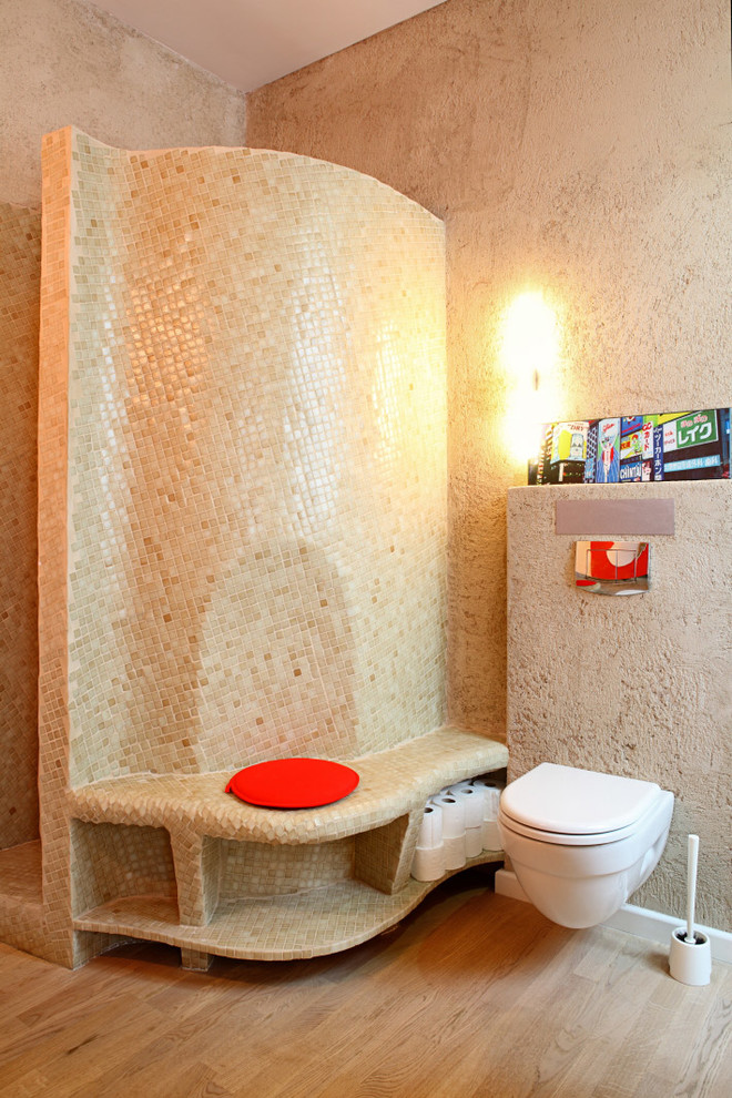 Foto på ett mellanstort medelhavsstil toalett, med en vägghängd toalettstol och mellanmörkt trägolv