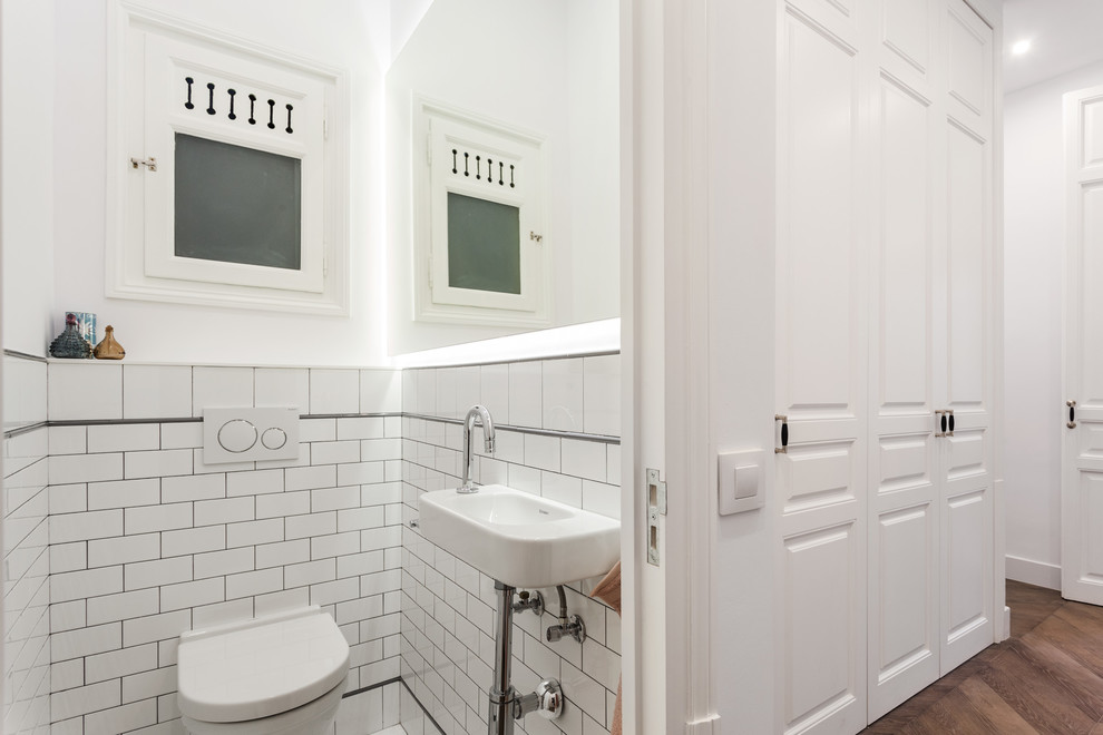 На фото: туалет в классическом стиле с инсталляцией, белой плиткой, плиткой кабанчик, белыми стенами и подвесной раковиной с