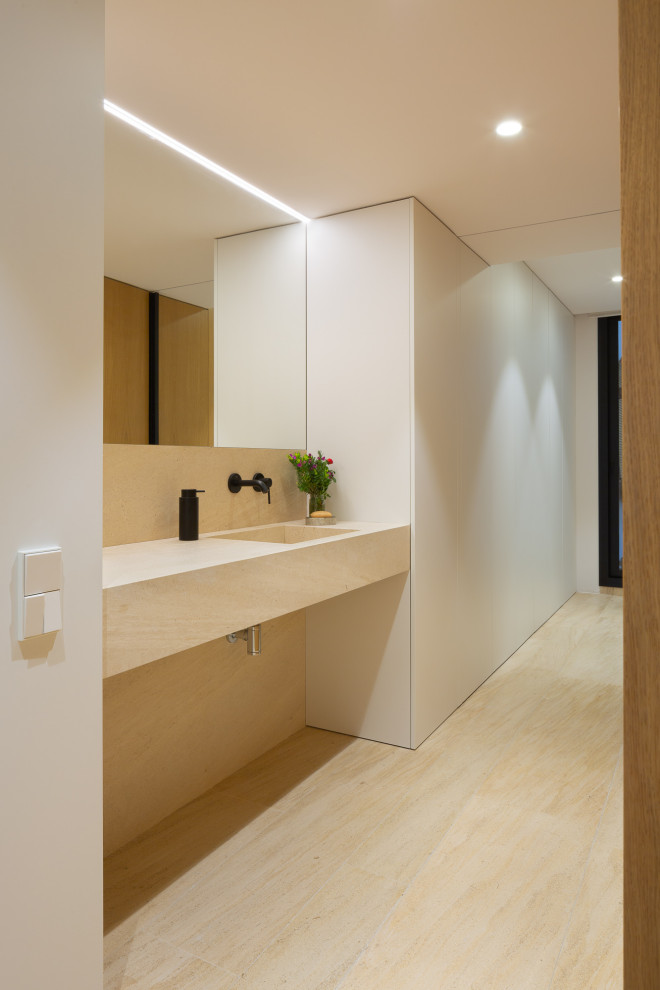 Exempel på ett modernt toalett, med bruna skåp, kalkstensgolv, ett integrerad handfat, bänkskiva i kalksten och brunt golv