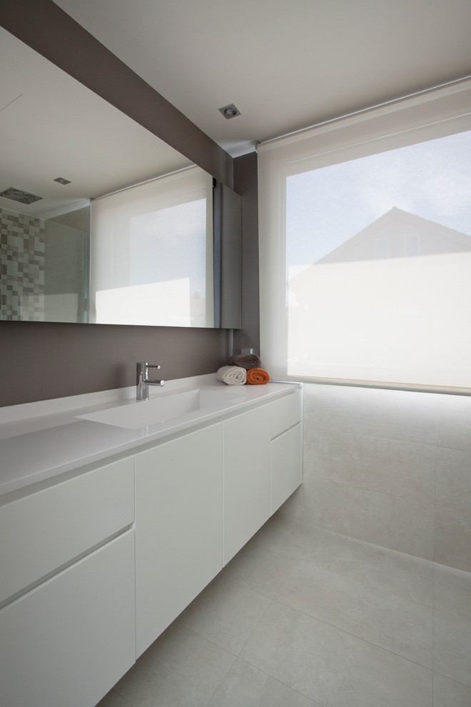 Mittelgroße Moderne Gästetoilette mit flächenbündigen Schrankfronten, weißen Schränken und integriertem Waschbecken in Sonstige