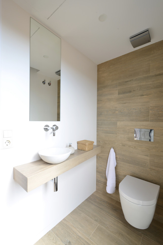 Photo of a medium sized contemporary cloakroom in Other with beige tiles, porcelain tiles, white walls, porcelain flooring, a vessel sink, wooden worktops, beige floors, beige worktops and a floating vanity unit.