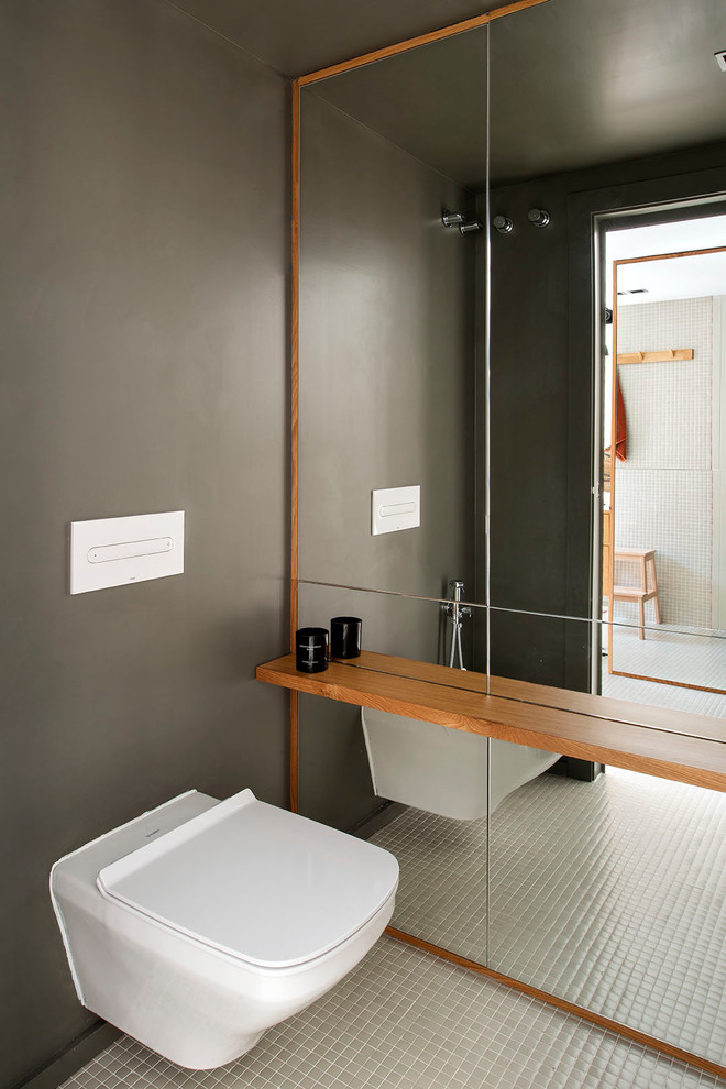 Пример оригинального дизайна: большой туалет в современном стиле с унитазом-моноблоком, зеленой плиткой, керамической плиткой, зелеными стенами и зеленым полом